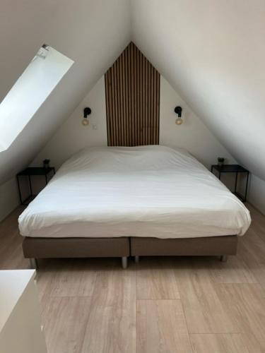 een slaapkamer met een bed op de zolder bij Veldt's huisje in Limmen