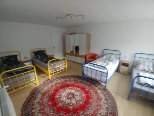a room with three beds and a rug at Monteur- und Ferienwohnung Gemmer 63qm in Herold
