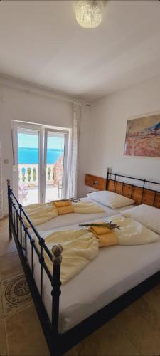 two beds in a bedroom with a view of the ocean at Bed & Breakfast BARBARA in Novi Vinodolski