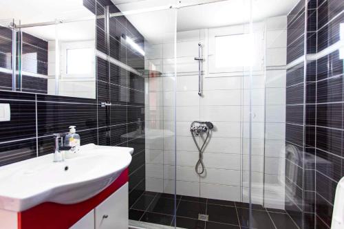 ein Bad mit einem Waschbecken und einer Dusche in der Unterkunft George Hotel Rooms&Suites in Himarë