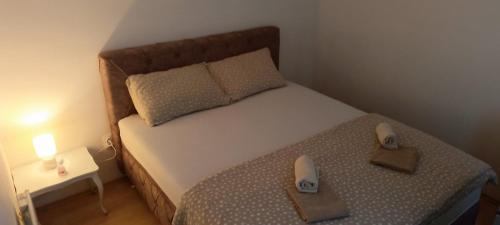 um pequeno quarto com uma cama com dois sapatos em Vikendica DUNAV em Novi Sad