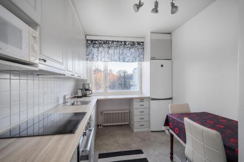 una pequeña cocina con fregadero y ventana en Sari’s place with nice view en Turku