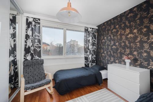 1 dormitorio con 1 cama, 1 silla y 1 ventana en Sari’s place with nice view en Turku