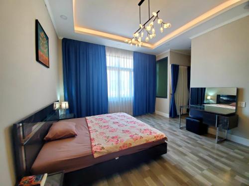 a bedroom with a large bed and a desk at Apartment in Vientiane