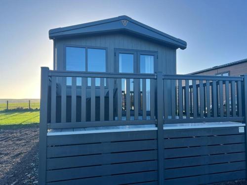 a smallshed with a bench on a fence at Eden Lodge StAndrews, peace and tranquility. in Strathkinness