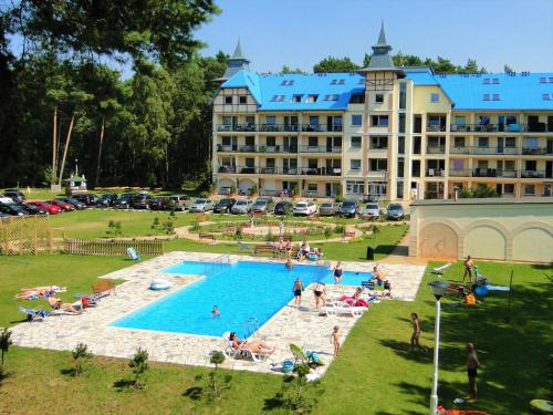 a large hotel with a large pool in front of it at Apartament HOME 206 Łukęcin BlueMare EPapartamenty in Łukęcin
