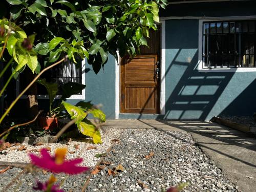 una casa azul con una puerta de madera y una flor en Casa Cuatro Lunas cerca de las playas y de la ciudad, en Lagunilla