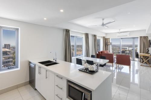 a kitchen and dining room with views of the city at Oaks Darwin Elan Hotel in Darwin