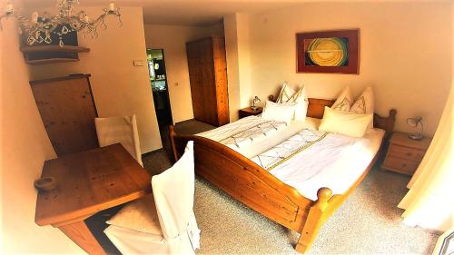 a bedroom with a wooden bed and a table at Landhaus Aflenz in Aflenz Kurort