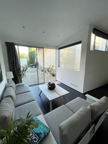 - un salon avec des canapés, une table et des fenêtres dans l'établissement Studio privé et jardin, à Marseille