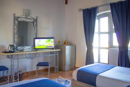 um quarto com 2 camas e uma secretária com uma televisão em Protels Beach Club & SPA em Marsa Alam