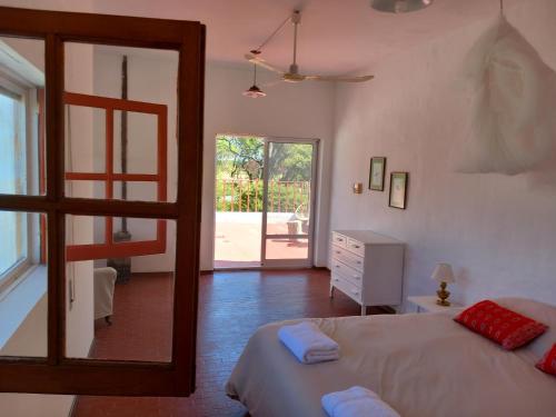Schlafzimmer mit einem Bett und einer Tür zu einer Terrasse in der Unterkunft Pampa Cottage 