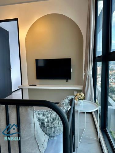 a living room with a tv and a table at Urban Suites Georgetown by BNB4U in Jelutong