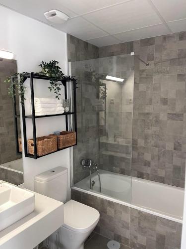 a bathroom with a toilet and a tub and a sink at Golden view costa del sol in Torre del Mar
