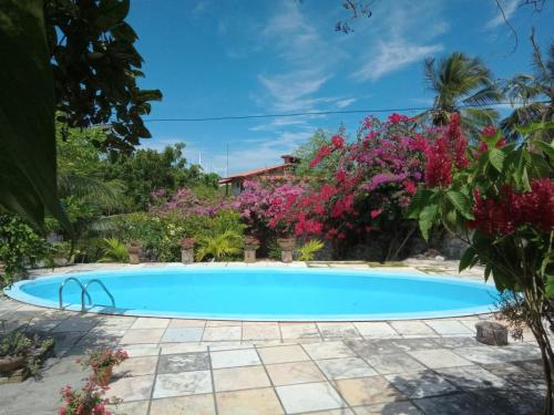 a swimming pool in front of a house with flowers at Casa Azul in Cascavel