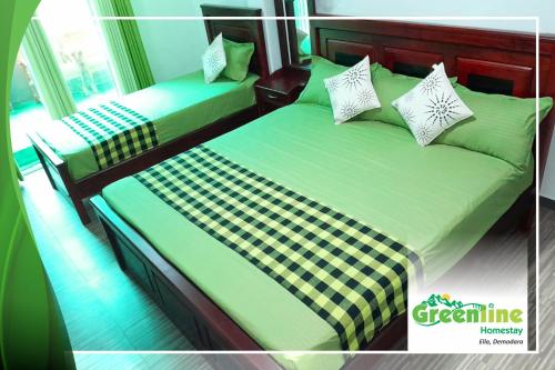 two beds in a room with green sheets and pillows at Greenline Homestay in Demodera