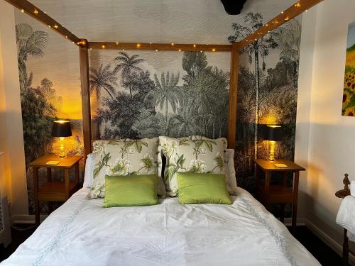 a bedroom with a bed with two green pillows at Church View a first floor apartment in the heart of historic Topsham in Topsham