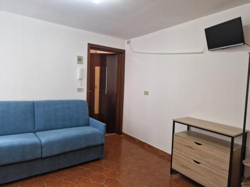 un soggiorno con divano blu e tavolo di Vico 2 monolocale ad Albissola Marina