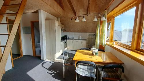 a kitchen and dining room with a wooden table and chairs at Ferienwohnung in Lemkenhafen auf Fehmarn in Fehmarn