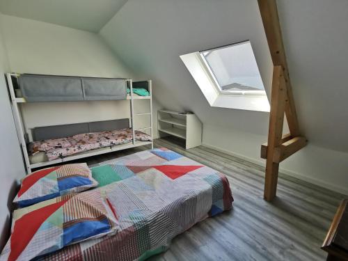 une chambre avec un lit superposé et une fenêtre dans l'établissement Aux portes de Chausey, à Saint-Pair-sur-Mer