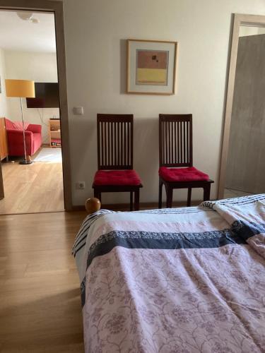 sypialnia z 2 krzesłami i łóżkiem w obiekcie Conny's w Akwizgranie