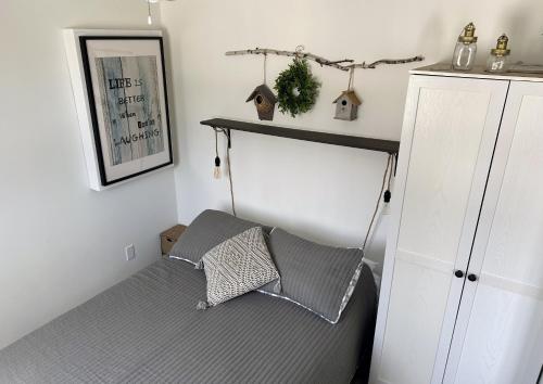 a bedroom with a bed and a shelf on the wall at Chalet Du Marais in Saint-Paulin