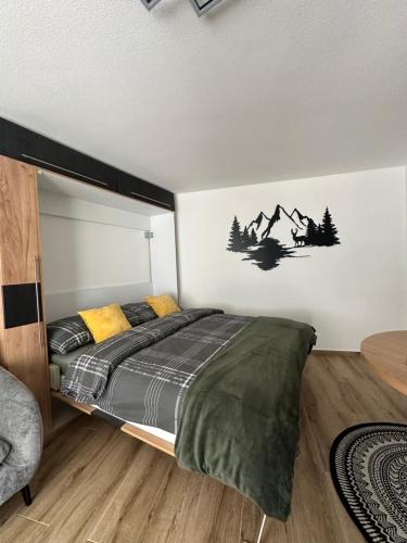 a bedroom with a bed with mountains on the wall at Studio magnifique avec terrasse spacieuse Loèche-les-Bains Vacances in Leukerbad