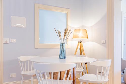 a white dining room with a table and chairs at Costamante Suites & Spa in Castellammare del Golfo