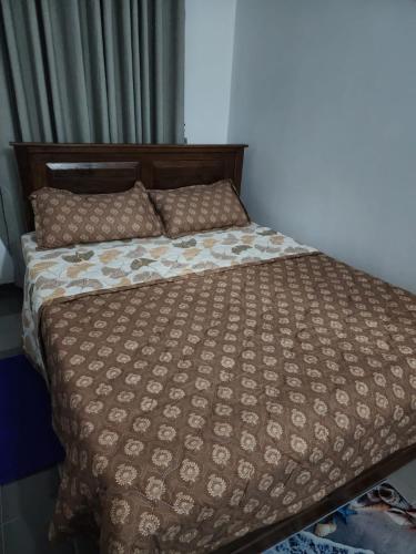a bed with a comforter and pillows on it at Andrews residence in Katunayake