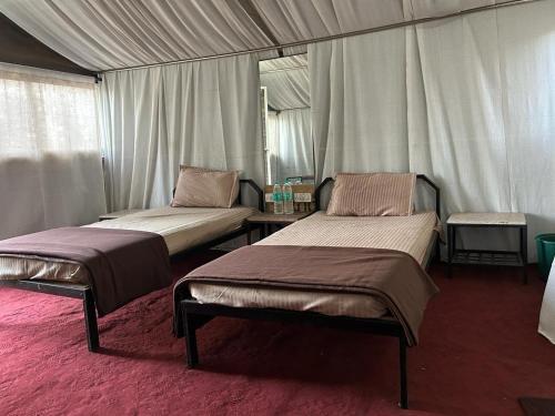 a room with two beds in a tent at Presidency Highland Resort in Koynanagar