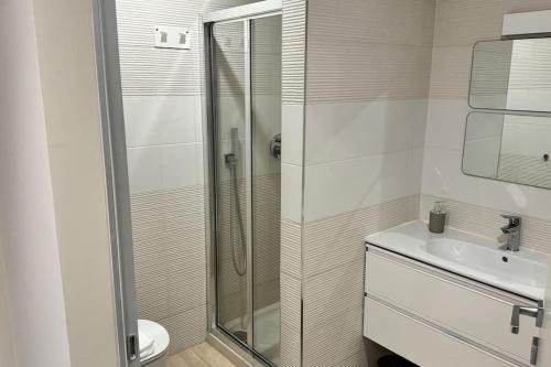 uma casa de banho branca com um chuveiro e um lavatório. em Resto appartamento 5 em Turim