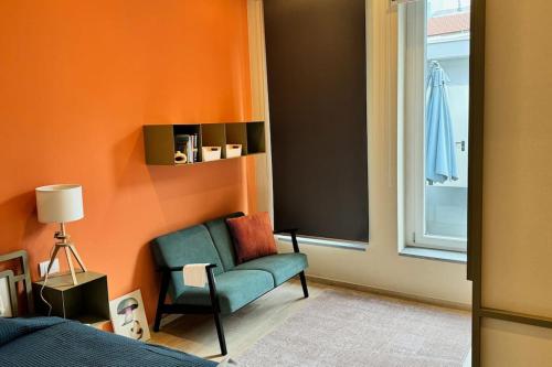 um quarto com uma cadeira verde e uma parede laranja em Resto appartamento 5 em Turim