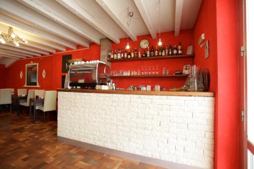 a red walled restaurant with a counter and a bar at Art Hotel in Mirano