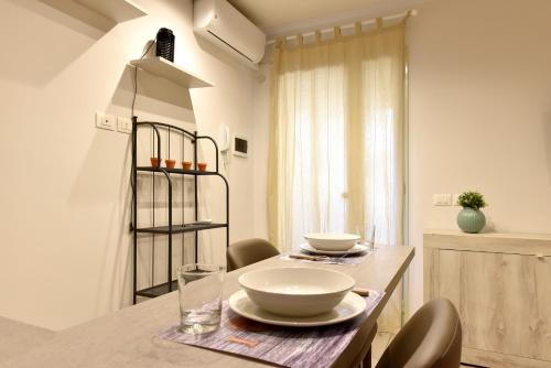 einem Esstisch mit Schalen und Tellern darauf in der Unterkunft Casa vacanza "Glicine" Taormina-Trappitello in Trappitello