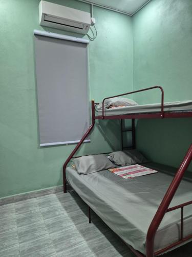 - łóżko piętrowe w pokoju z tablicą w obiekcie Teratak Che Esah Guest House FREE WIFI NETFLIX w mieście Pasir Mas