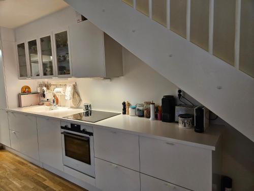 a kitchen with white cabinets and a sink at Ny og moderne leilighet, midt i byen1 in Trondheim