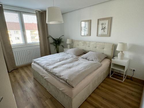 um quarto com uma cama grande num quarto com uma janela em Neue stilvolle 2-Zimmer Wohnung im Zentrum von Wolfsburg em Wolfsburg