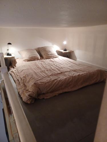un grand lit dans une chambre avec deux lampes dans l'établissement 4 RUE MERCIER, à Sète