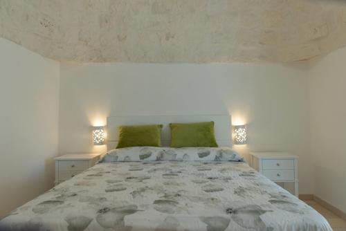 um quarto com uma cama grande e almofadas verdes em Masseria Carperi in the heart of Valle d'Itria em Cisternino