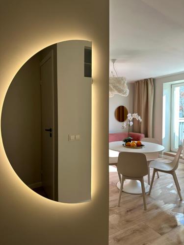 a living room with a table and a mirror at C a r p e D i e m in Ventspils