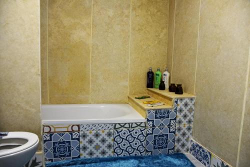 a bathroom with a tub and a toilet at Pyramids Temple Guest House in Cairo
