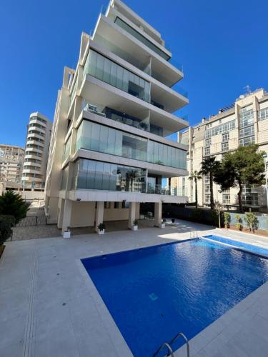 a building with a swimming pool in front of a building at Calpe Beach II - sea & pool view apartment in Calpe