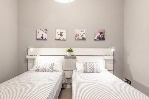 two twin beds in a bedroom with pictures on the wall at Laserrafelice in Imperia