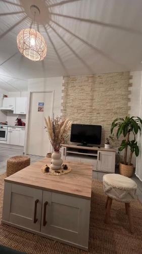 un salon avec une table et une télévision dans l'établissement Appartement T2 cosy et calme, à Bayonne
