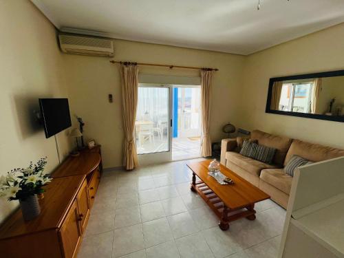 a living room with a couch and a table at Bravo Hills Apartment in Ciudad Quesada
