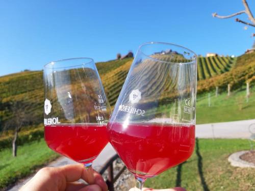 two people holding glasses of red wine at Naturjuwel inmitten der Weinberge in Sankt Stefan ob Stainz