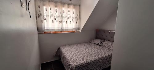 a small bedroom with a bed and a window at Hospedaje dominguez in Oxapampa