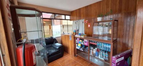 a room with a drink cooler and a leather chair at Hospedaje dominguez in Oxapampa