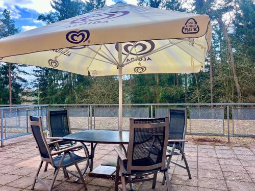 a table and chairs under an umbrella on a patio at Apartmán Lakeside in Český Krumlov