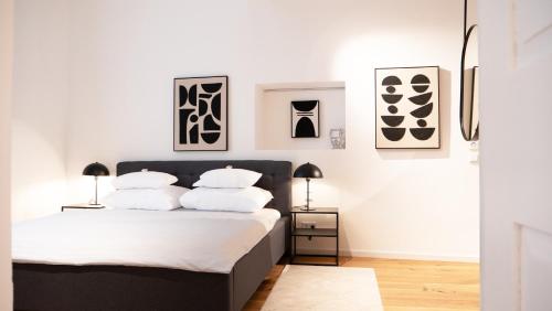 a bedroom with white walls and a bed with white pillows at Smile Apartments im Stadtzentrum in Krems an der Donau